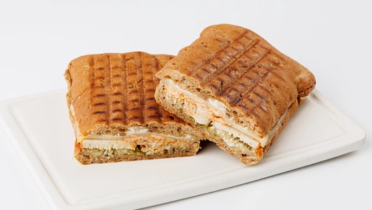 Панини с курицей-гриль, моцареллой и огуречным релишем, кафе Панини с курицей-гриль, моцареллой и огуречным релишем, кафе