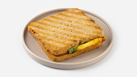 Сэндвич с беконом и скрэмблом на хлебе с отрубями, кафе