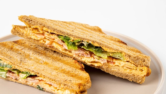 Сэндвич с беконом и скрэмблом на хлебе с отрубями, кафе